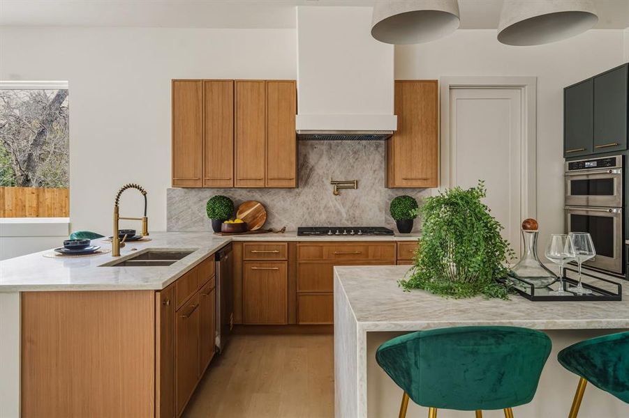 Kitchen with light stone counters, a kitchen bar, a peninsula, and brown cabinets