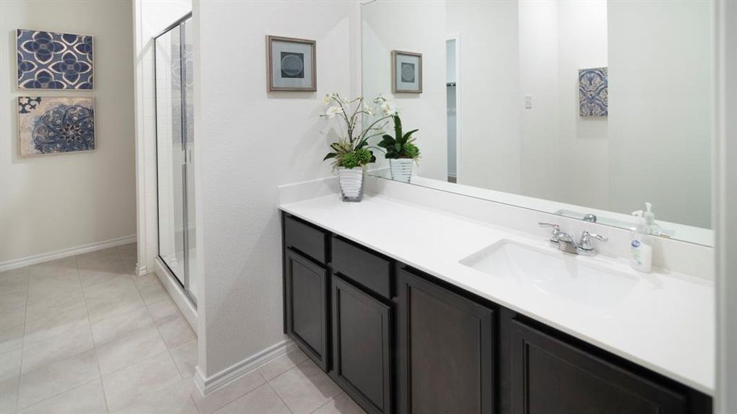 Bathroom with vanity, a stall shower, and light tile patterned floors