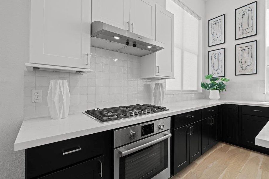 A sleek, contemporary kitchen with dark cabinetry and light countertops provides a chic cooking environment. A sleek, contemporary kitchen with dark cabinetry and light countertops provides a chic cooking environment.