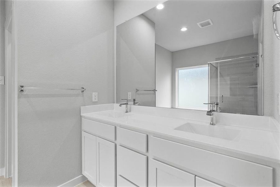 This primary bathroom is definitely move-in ready! Featuring stained cabinets with light countertops, spacious walk-in closet with shelving, high ceilings, custom paint, sleek modern finishes.