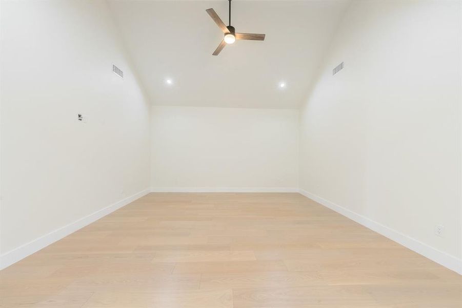 Spare room featuring vaulted ceiling, light wood-style floors, ceiling fan, and recessed lighting Spare room featuring vaulted ceiling, light wood-style floors, ceiling fan, and recessed lighting