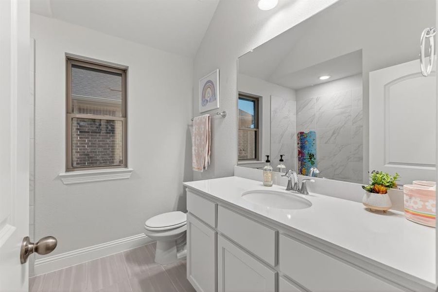 Bathroom featuring vanity and vaulted ceiling Bathroom featuring vanity and vaulted ceiling