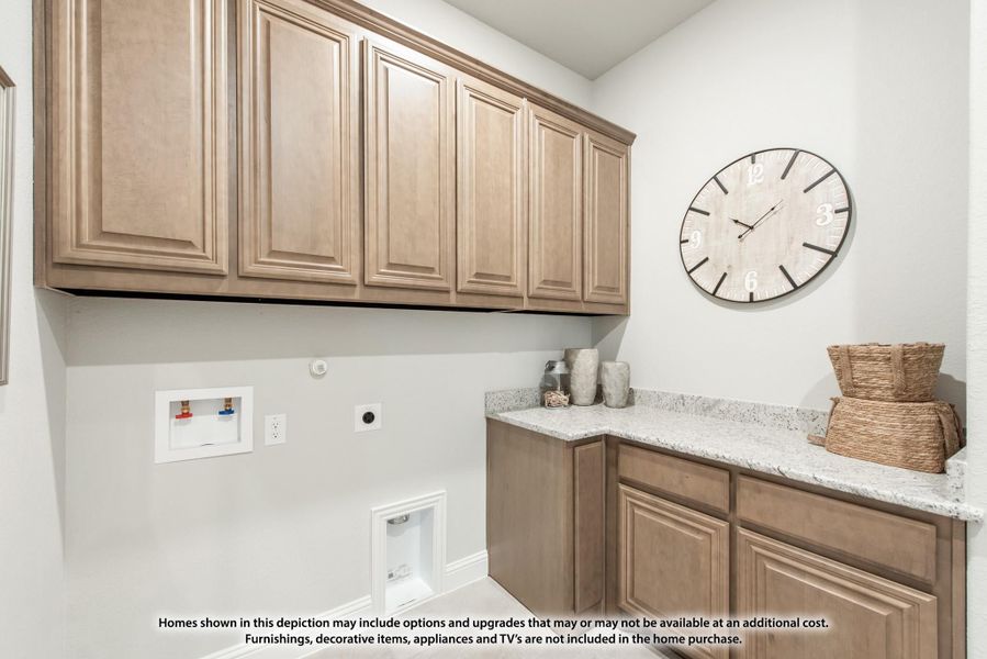 Laundry room with tan wood cabinets, granite countertop, and washer and dryer hookups on white walls Laundry room with tan wood cabinets, granite countertop, and washer and dryer hookups on white walls