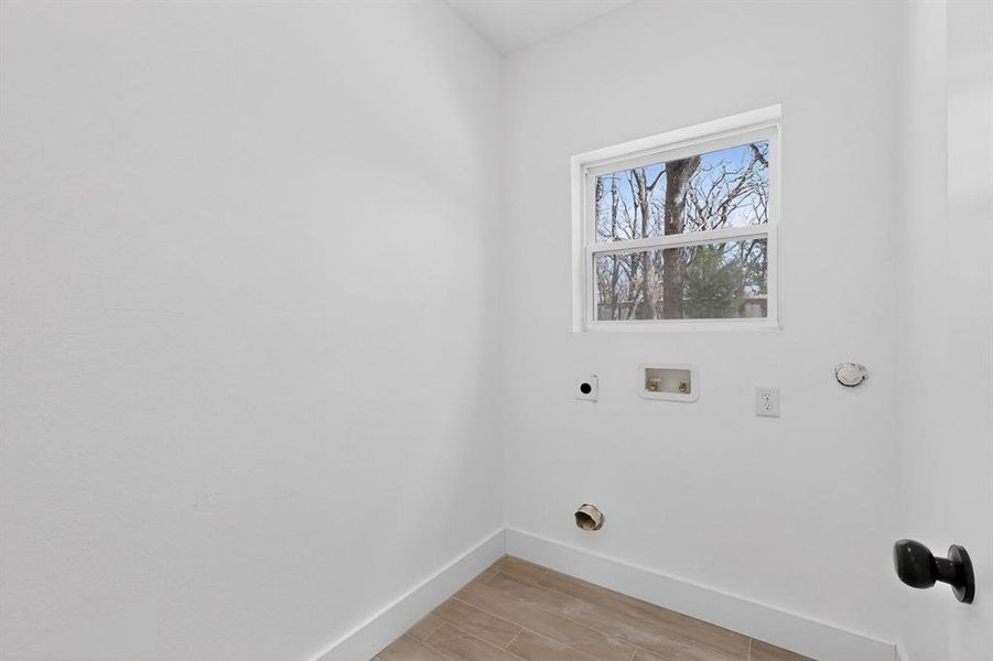 Laundry room featuring wood finish floors, hookup for a washing machine, and electric dryer hookup