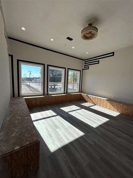 Empty room with dark wood-type flooring and recessed lighting