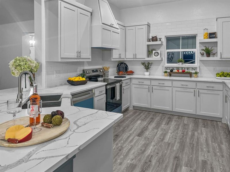 Kitchen w electric range vent hood, appliances with stainless steel finishes, backsplash, light quartz counters