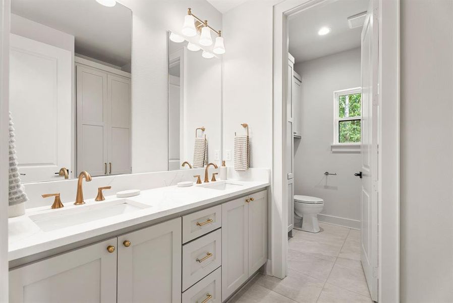 Bathroom featuring double vanity, light tile patterned floors, a closet, and recessed lighting