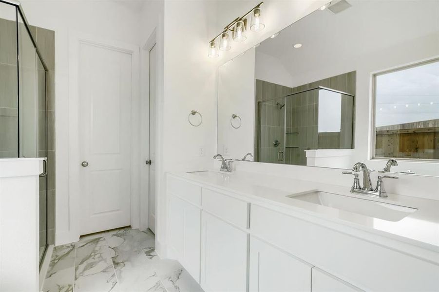 Dual vanity featuring undermount sinks, chrome fixtures, and a large mirror