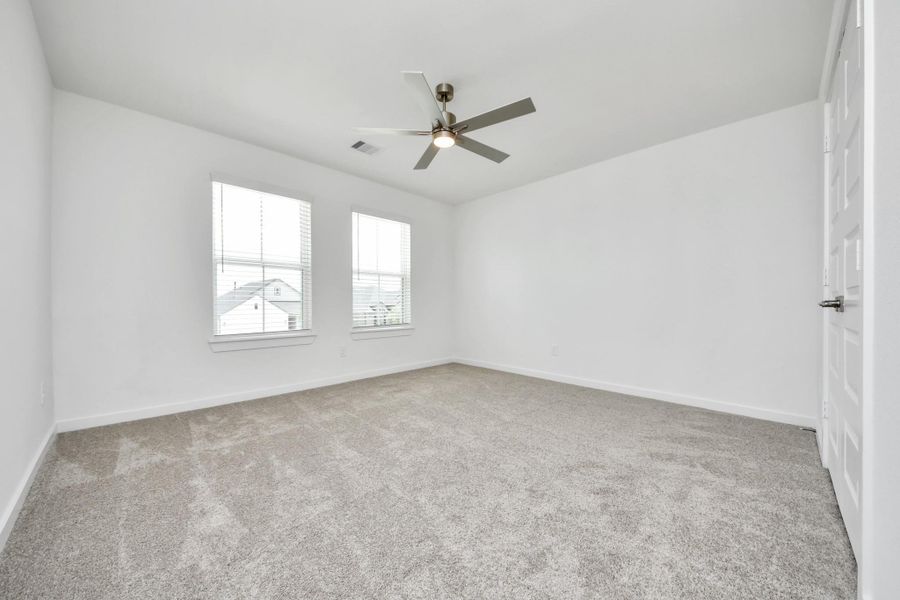 Secondary bedroom features plush carpeting, large windows that let in plenty of natural light, bright paint, and spacious closets.
