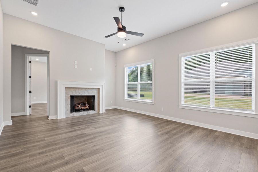 Spacious living area featuring high ceilings, recessed lighting, and wood-finish flooring Spacious living area featuring high ceilings, recessed lighting, and wood-finish flooring