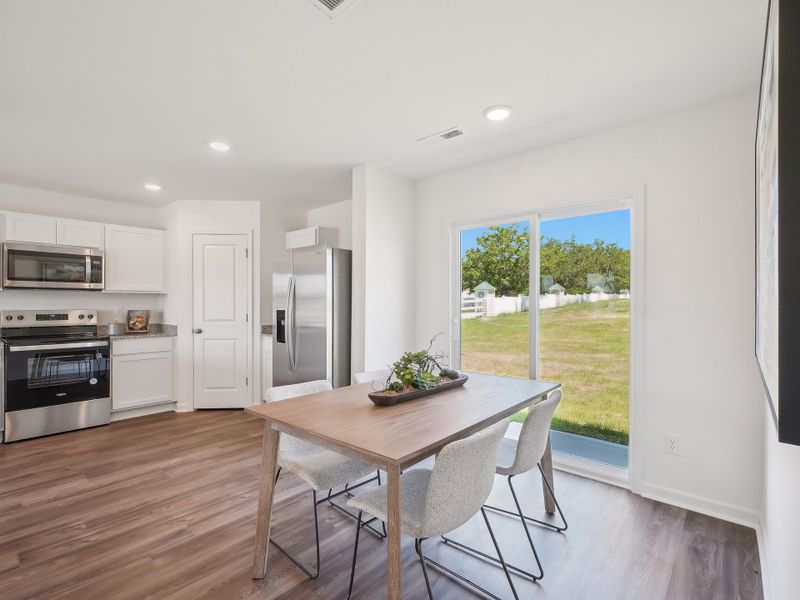 A kitchen with a table and chairs. A kitchen with a table and chairs.