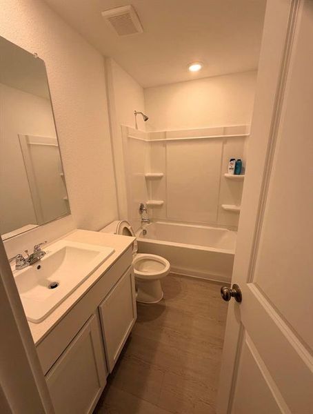 Bathroom featuring a white vanity with integrated sink, chrome faucet, and a large wall-mounted mirror Bathroom featuring a white vanity with integrated sink, chrome faucet, and a large wall-mounted mirror