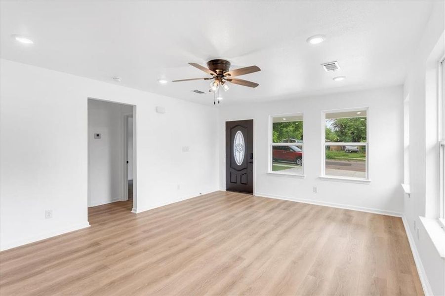 Living room featuring ceiling fan and light wood floors