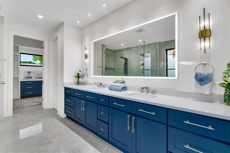 Bathroom featuring double vanity, a shower stall, and recessed lighting