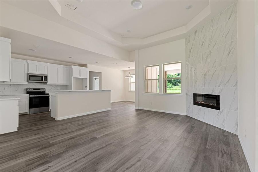 Spacious living with tiered ceiling and floor to wall fireplace Spacious living with tiered ceiling and floor to wall fireplace