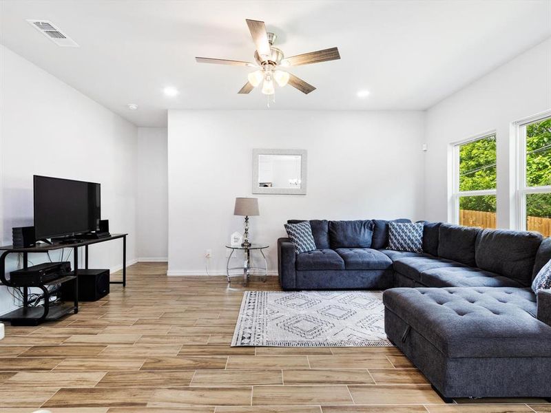 Spacious living area featuring wood-finish flooring, recessed lighting, and a ceiling fan