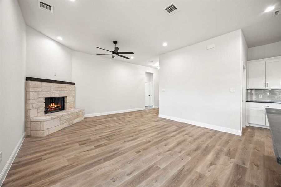 Unfurnished living room with recessed lighting, light wood finished floors, a fireplace, and a ceiling fan