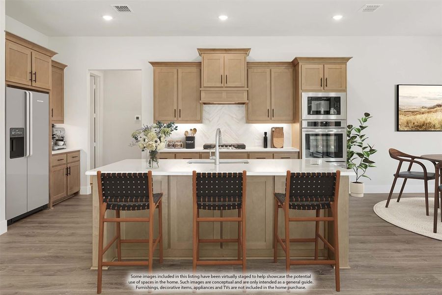 Kitchen with light wood cabinets, center island with three bar stools, and stainless steel appliances
