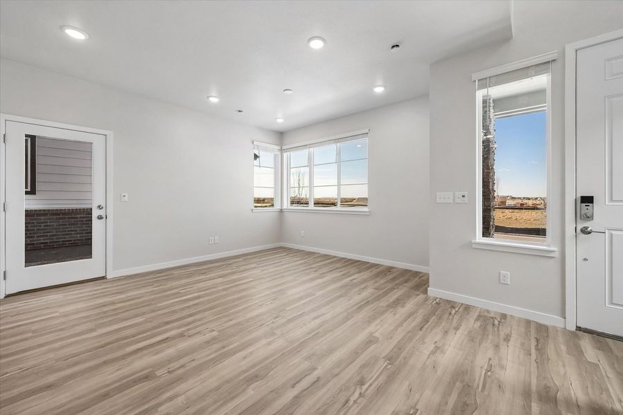A room with a wood floor and windows.