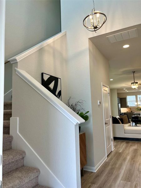 Stairway with wood finished floors, recessed lighting, a chandelier, and ceiling fan Stairway with wood finished floors, recessed lighting, a chandelier, and ceiling fan