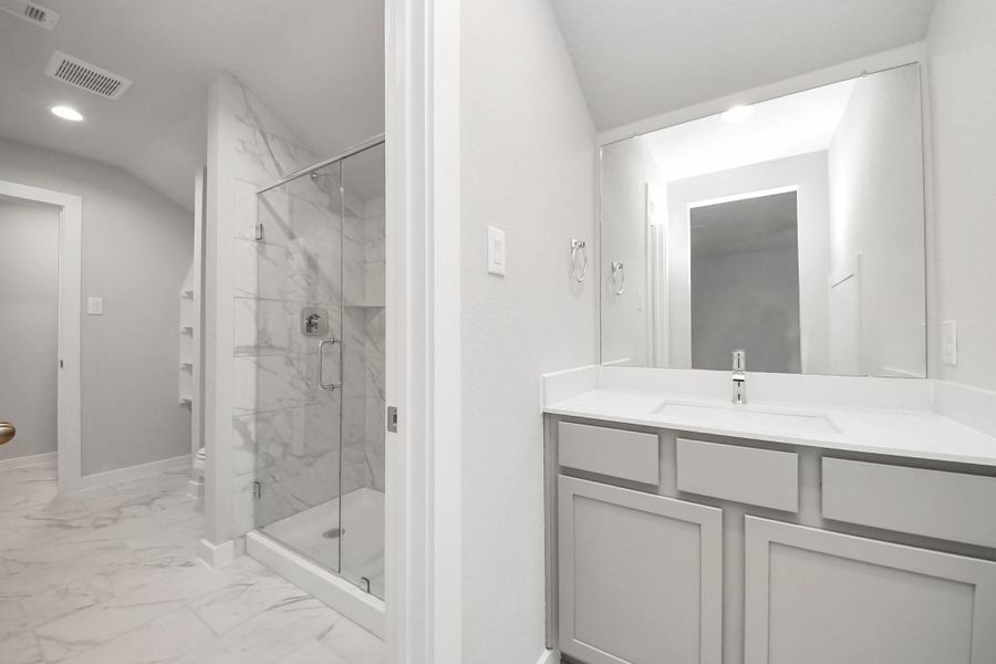 Experience convenience in the secondary bathroom, designed for Jack and Jill arrangements, now with a separate vanity area. This well-appointed space showcases stylish tile flooring, a bath/shower combo with an elegant tile surround, and light-stained wood cabinets. The beautiful light countertop adds a touch of sophistication, combining functionality and aesthetics seamlessly. Experience convenience in the secondary bathroom, designed for Jack and Jill arrangements, now with a separate vanity area. This well-appointed space showcases stylish tile flooring, a bath/shower combo with an elegant tile surround, and light-stained wood cabinets. The beautiful light countertop adds a touch of sophistication, combining functionality and aesthetics seamlessly.