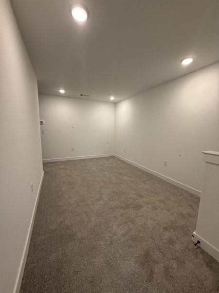 Carpeted spare room featuring recessed lighting and baseboards