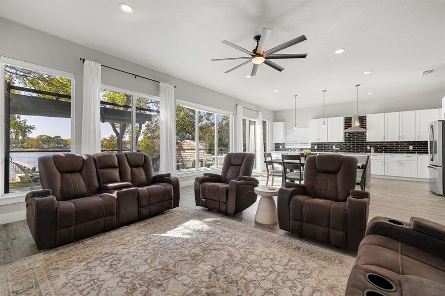 Living room featuring recessed lighting, light wood-style floors, and a ceiling fan