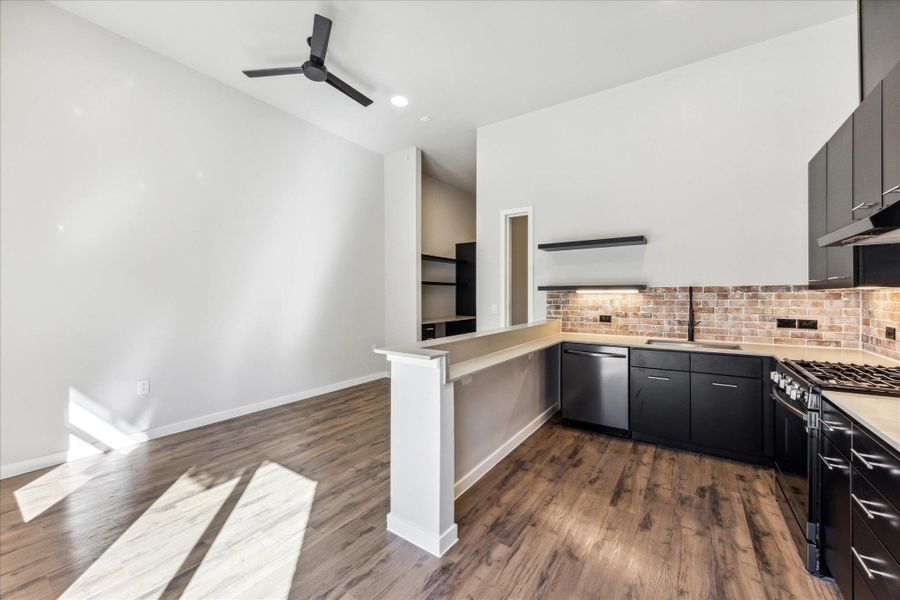 High ceilings crown an open-plan kitchen and living area featuring stylish wood flooring and modern fixtures. High ceilings crown an open-plan kitchen and living area featuring stylish wood flooring and modern fixtures.