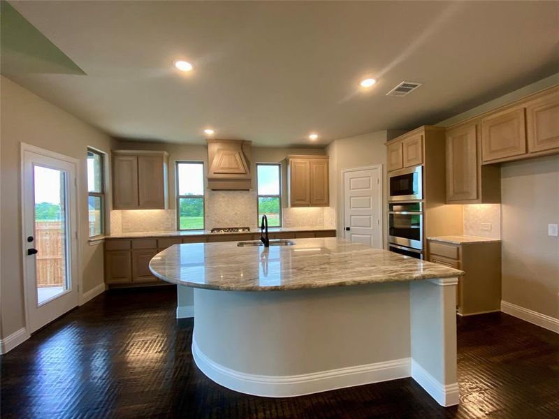 Gourmet kitchen with Champagne cabinets,decorative mosaic tile backsplash, and Fantasy Brown granite counters