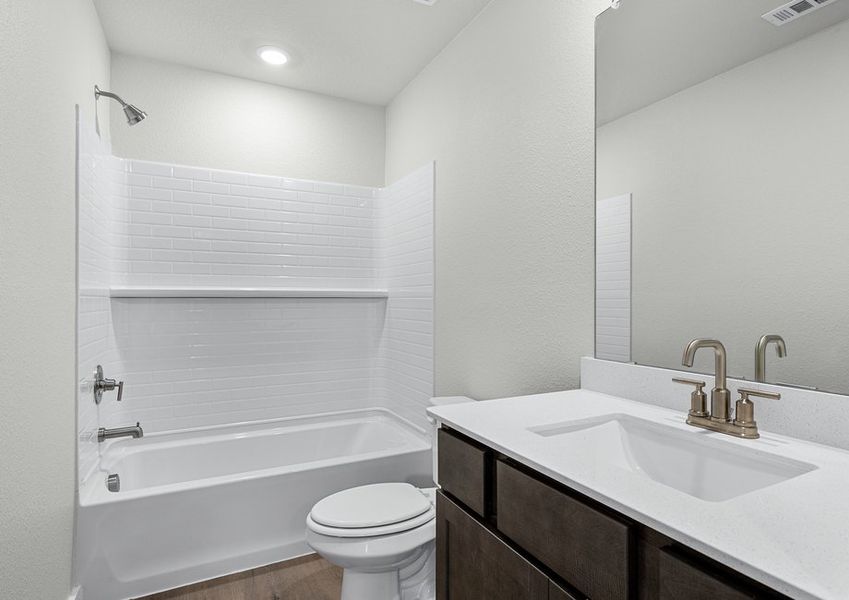 The secondary bathroom has a sprawling vanity space and a shower-tub combo.