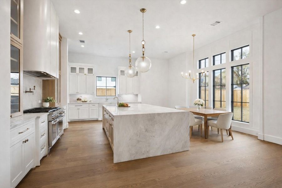 Statement waterfall quartz island anchors this light filled chef kitchen. Oversized black framed windows, and a dedicated breakfast nook create a seamless open concept layout designed for elevated everyday living and effortless entertaining. *Virtually Staged*