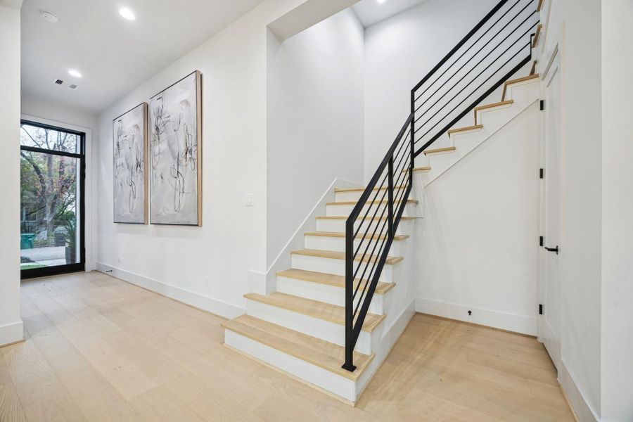 Entrance of the home with a stunning wrought iron staircase.