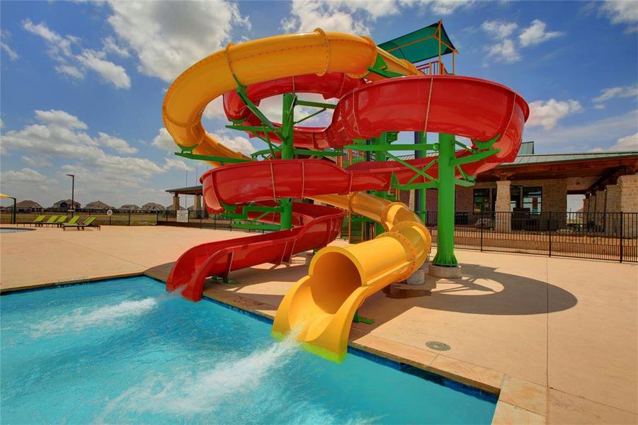 Large multi-lane water slide complex with multiple red and yellow slides emptying into a pool