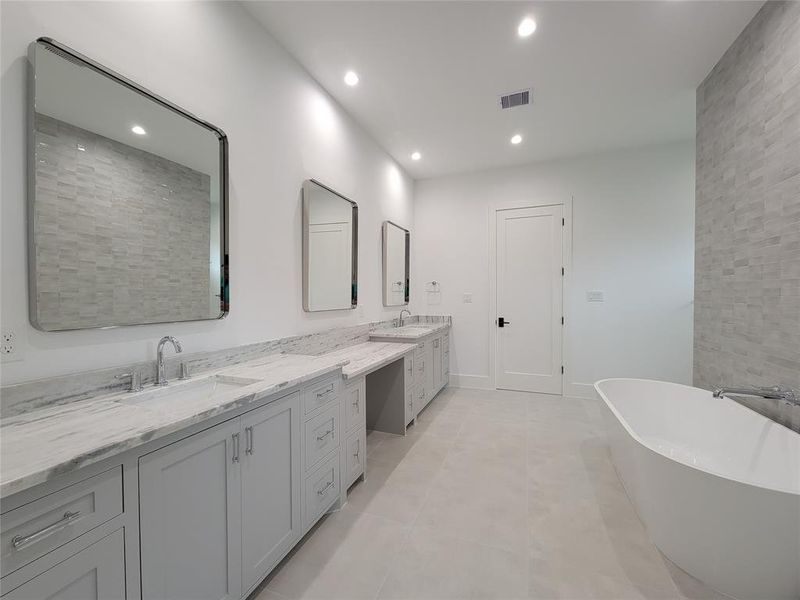 Luxurious primary bath with double vanity, under mount sinks, granite counter tops, shaker style cabinets & LED recessed lighting