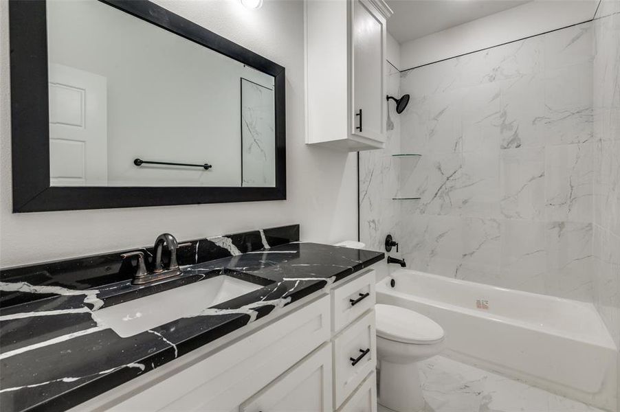 Full bathroom featuring vanity, toilet, and tiled shower / bath