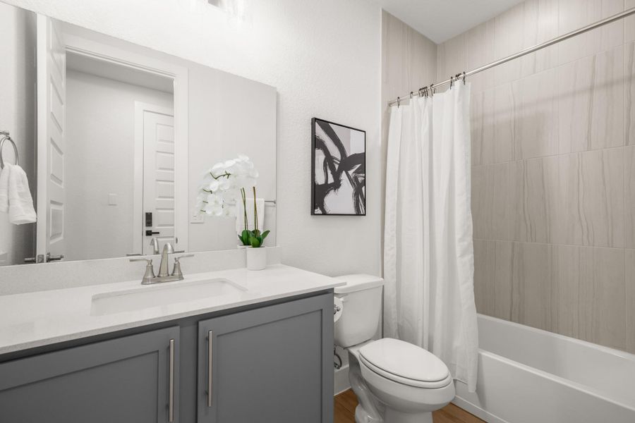 Bathroom with vanity, shower / tub combo with curtain, and light wood-type flooring