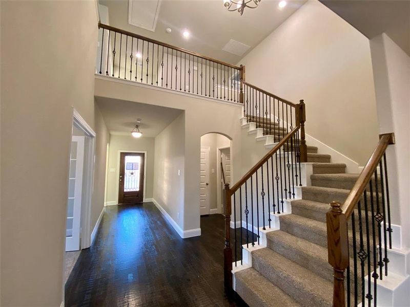 High cathedral ceilings with elegant wrought iron spindles on staircase