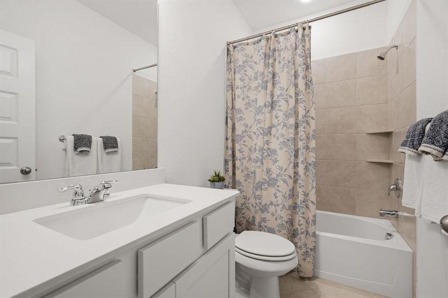 Downstairs full bath with fresh neutral finishes, tiled tub-shower combo, and bright vanity space. Perfect for guests or secondary bedrooms.