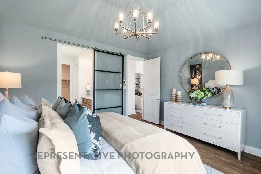 Bedroom with a chandelier and dark wood finished floors Bedroom with a chandelier and dark wood finished floors