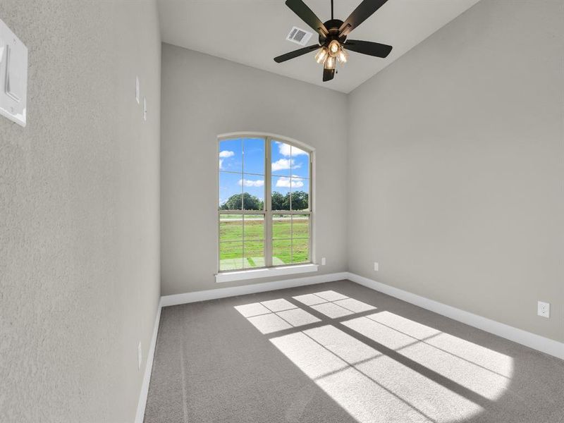 Carpeted spare room featuring baseboards and a ceiling fan Carpeted spare room featuring baseboards and a ceiling fan
