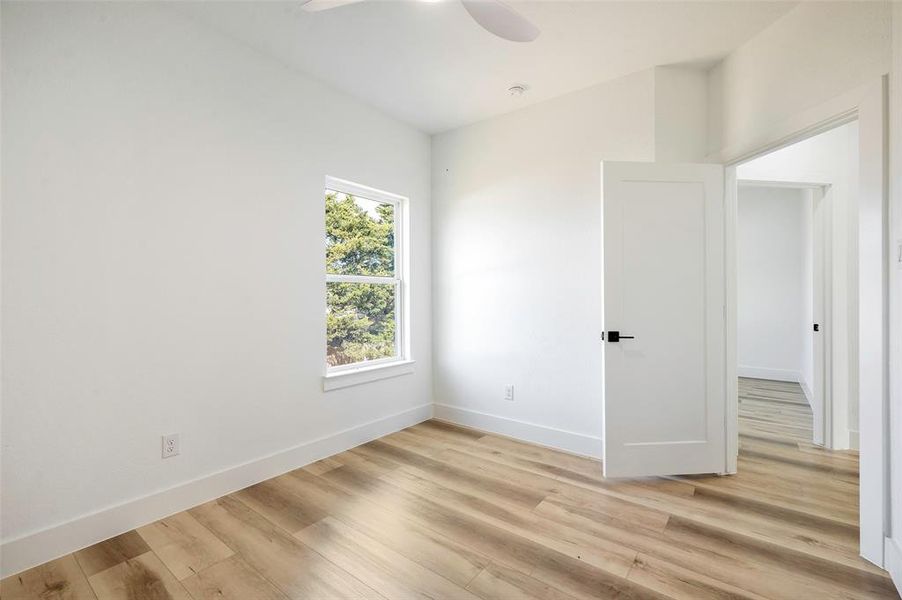 Unfurnished room with ceiling fan and light wood-type flooring