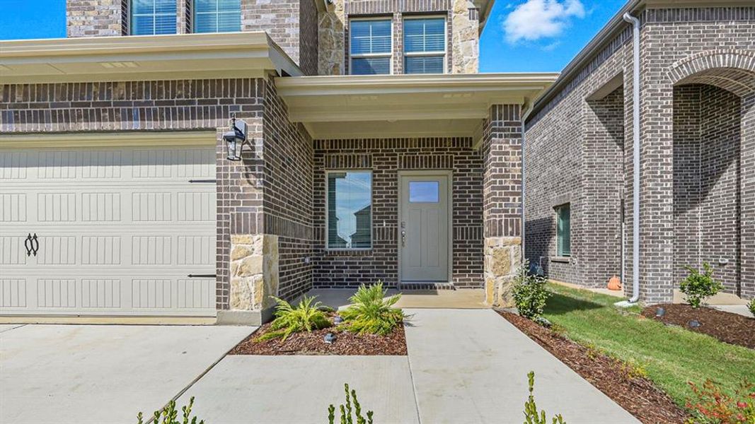 Property entrance featuring brick siding and a porch Property entrance featuring brick siding and a porch