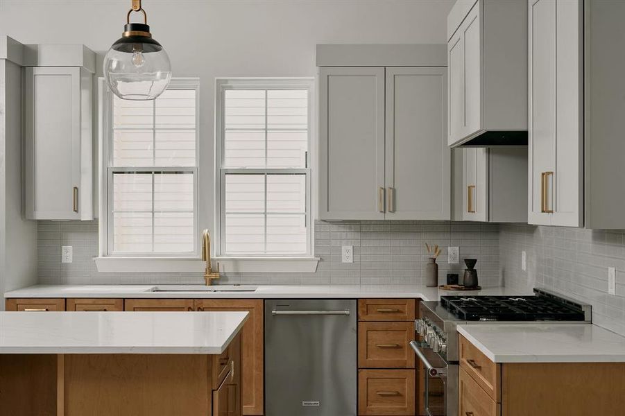 Contemporary kitchen featuring light wood cabinetry and light gray upper cabinets Contemporary kitchen featuring light wood cabinetry and light gray upper cabinets