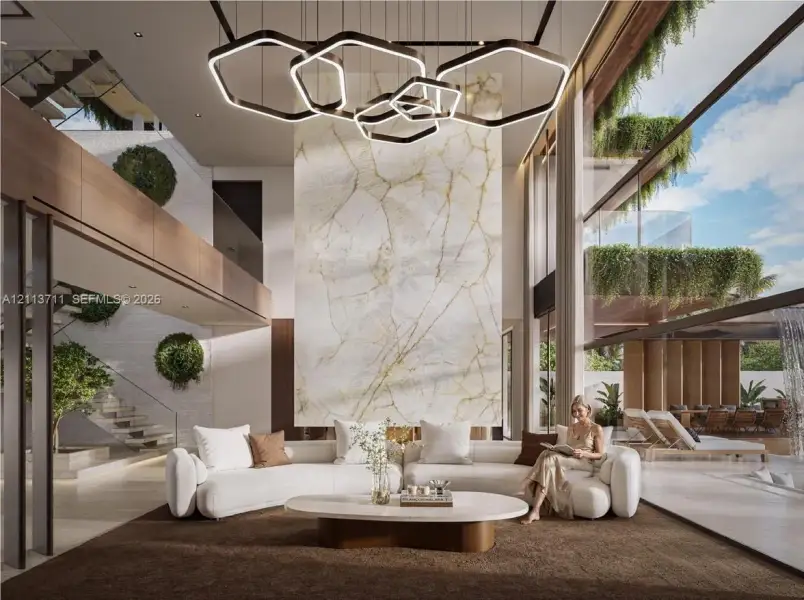 Double-height ceiling, floor-to-ceiling glass walls, full-height stone-clad fireplace surround, custom geometric multi-tier pendant lighting, and floating staircase with glass railing