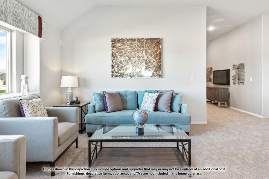 Living room with vaulted ceiling, blue sofa, gray chairs, glass coffee table, and carpet flooring