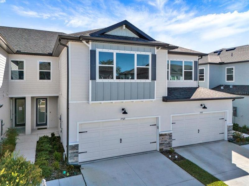 Front exterior of a new home in The Towns At Long Bayou, Seminole, FL, highlighting curb appeal (Image 1). Front exterior of a new home in The Towns At Long Bayou, Seminole, FL, highlighting curb appeal (Image 1).
