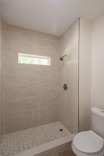 Bathroom with toilet and a tile shower