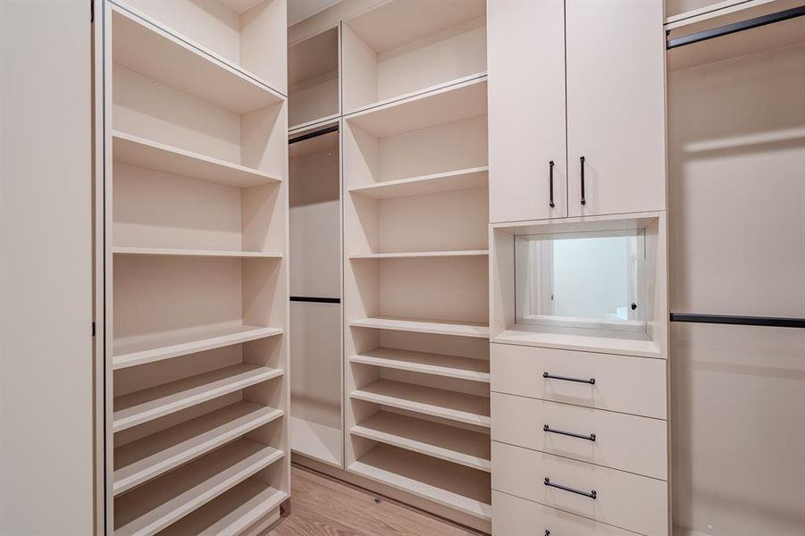 Walk in closet with light wood finished floors Walk in closet with light wood finished floors