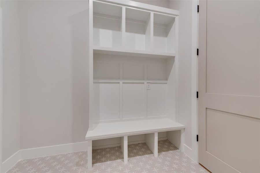 Mudroom featuring light tile floors