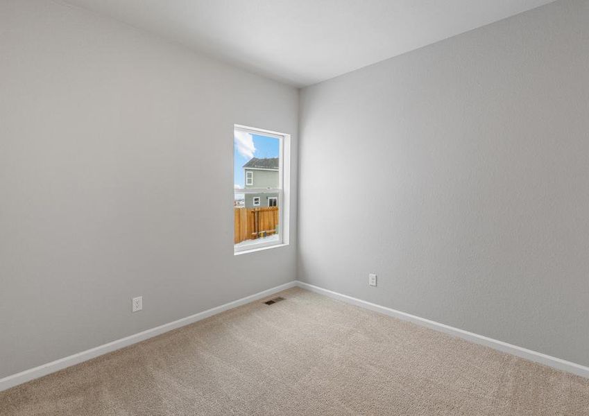 Secondary bedroom with a window, recessed lighting and tan carpet.